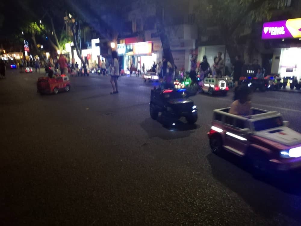 ハノイ夜市で電動カーで遊ぶ子供たち