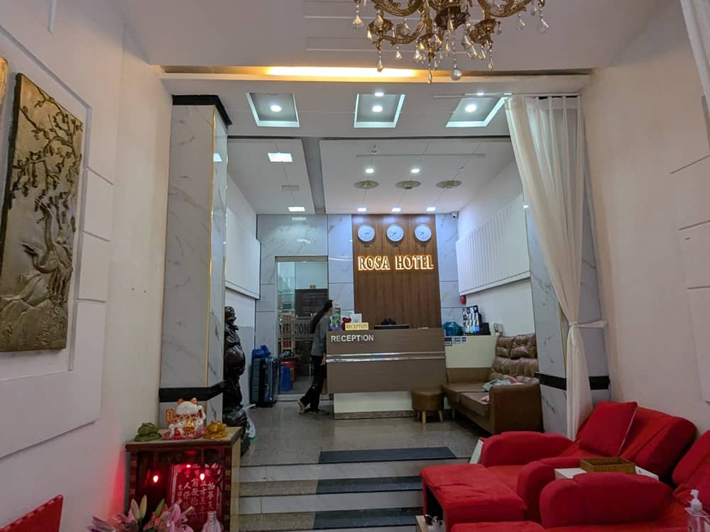 「ROSA HOTEL」のロビー。受付カウンターと赤いマッサージ用チェアが見える。
