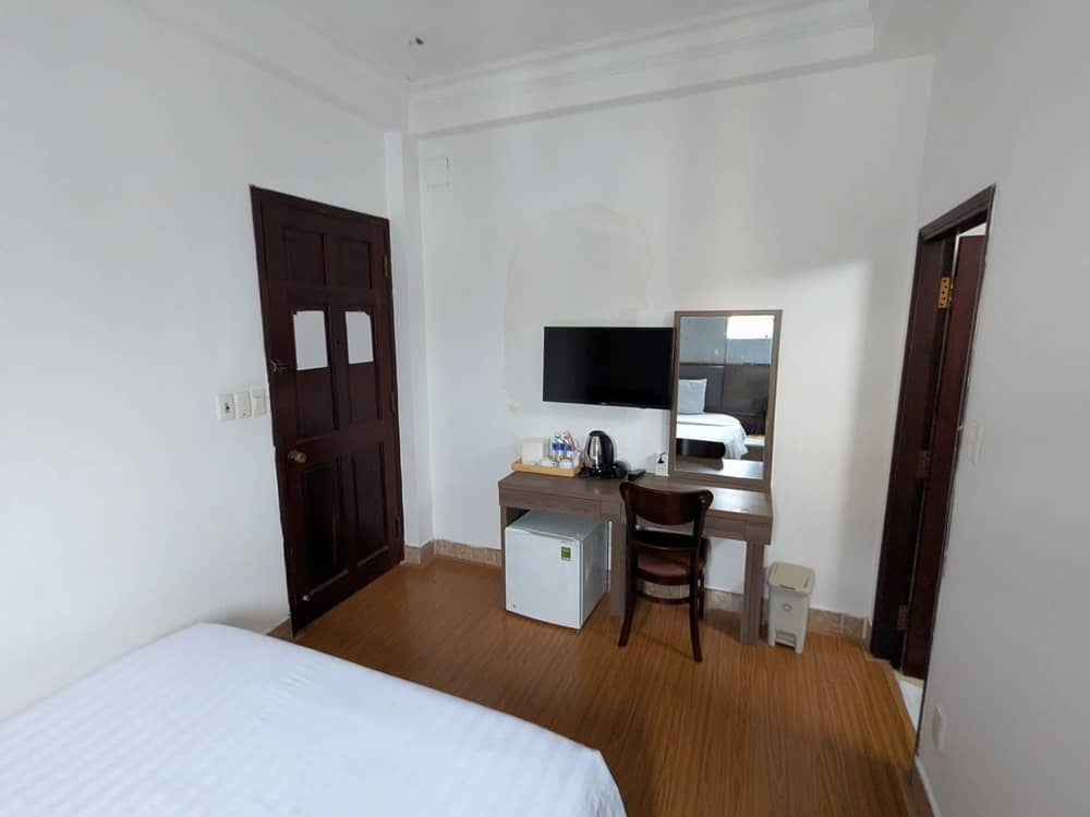 「ROSA HOTEL」の室内の様子。部屋のドア、ドレッサー、鏡がある。