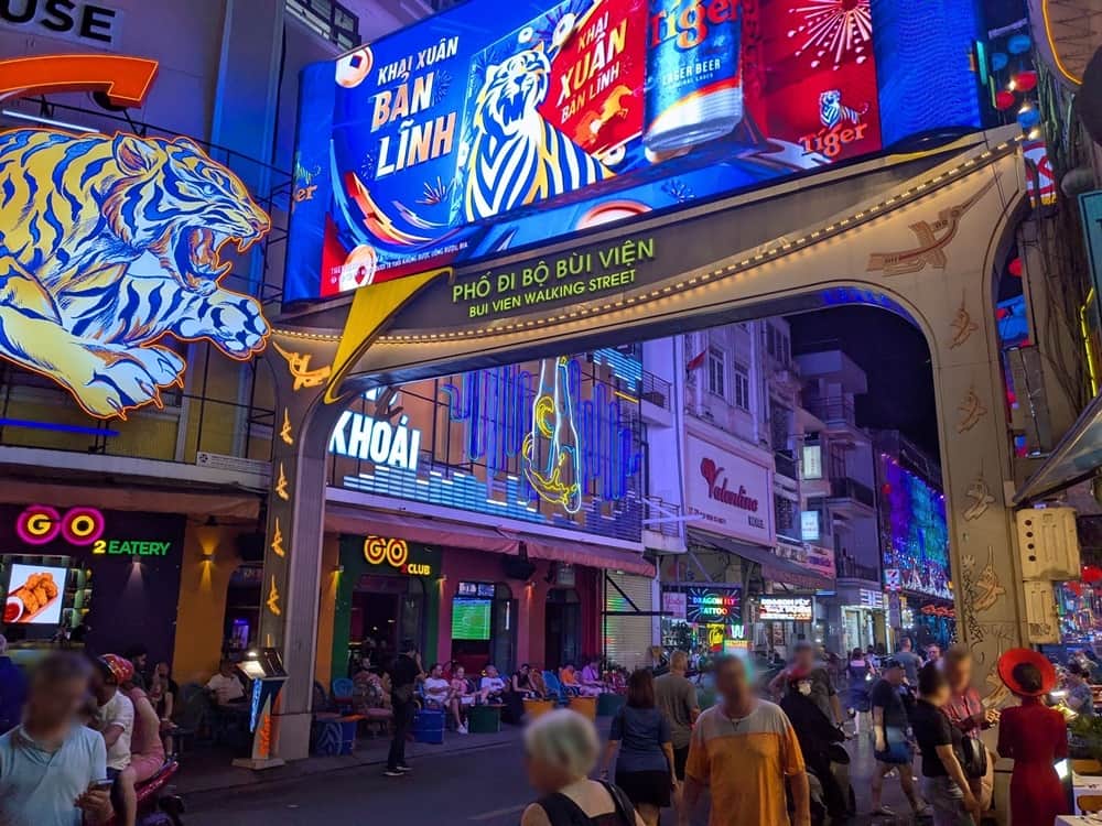 夜のブイビエン通りの象徴的な門。大勢の人が行きかう風景。