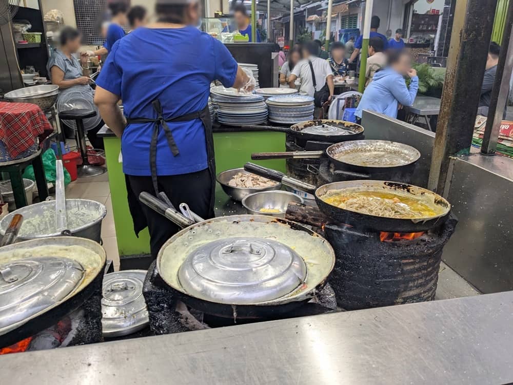 いくつもの炭火台の上に置かれた中華鍋で作られている特大バインセオ。